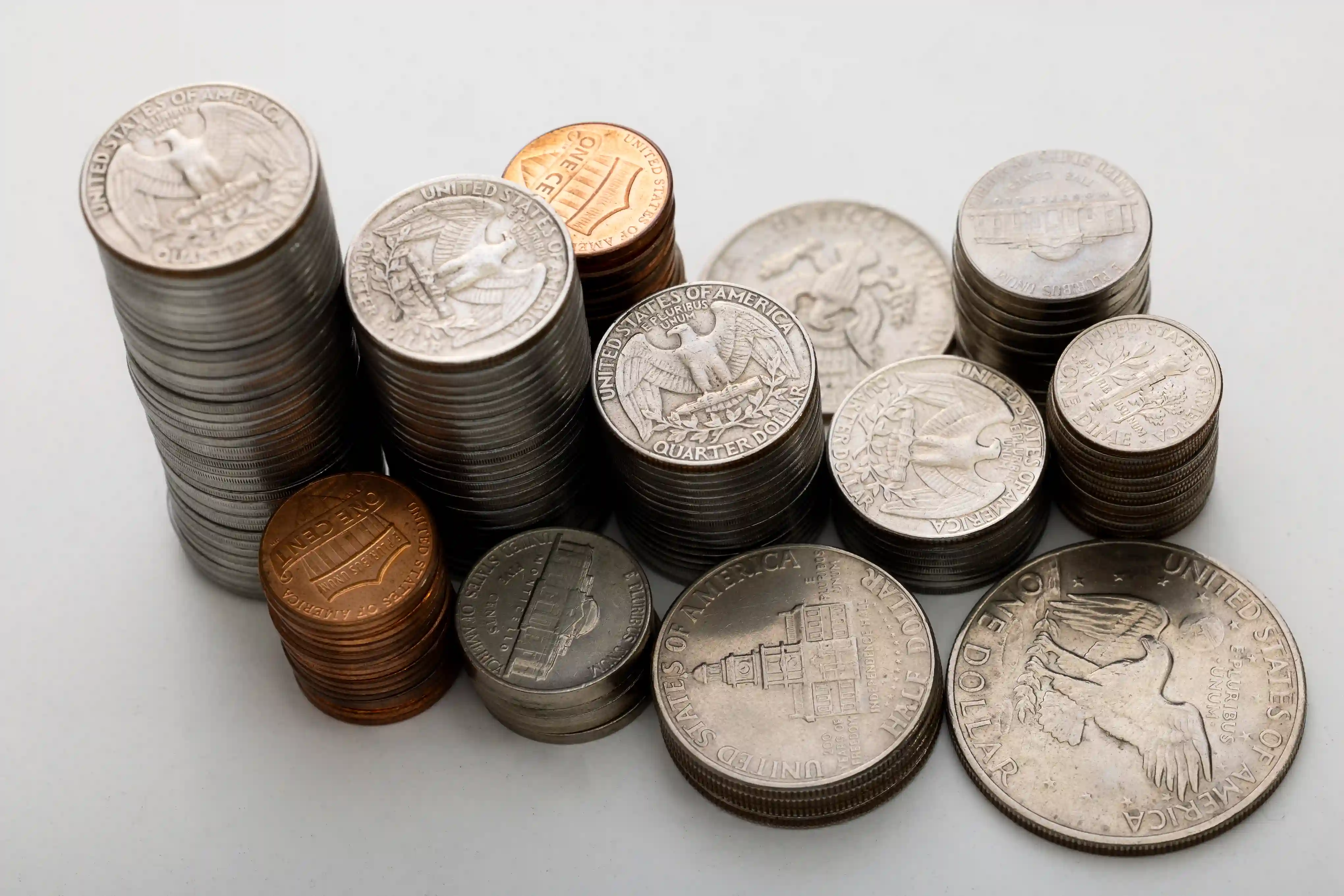 many different coins on a white surface
